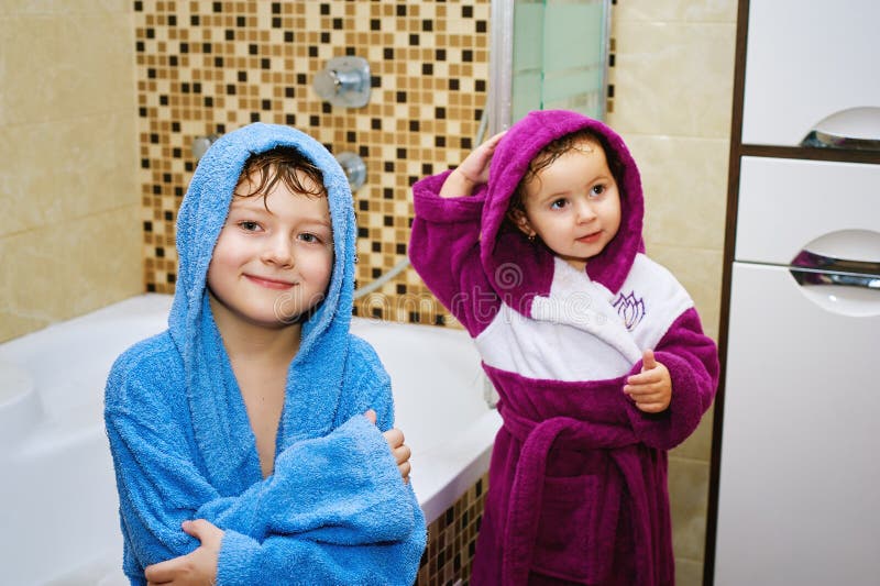 Brother and sister in the bathroom in bright robes. Brother and sister in the bathroom in bright robes