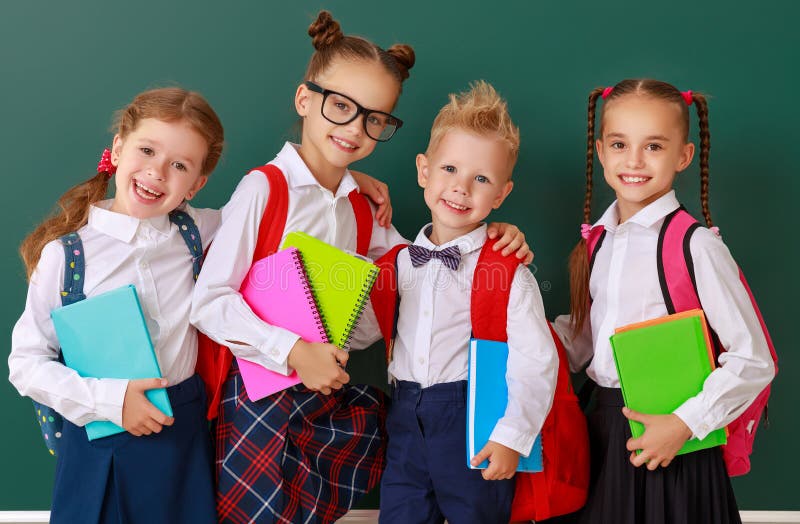 Crianças engraçadas estudante e estudante, menino do estudante e menina do grupo sobre o quadro-negro da escola foto de stock Crianças engraçadas estudante e estudante, menino do estudante e menina do grupo sobre o quadro-negro da escola foto de stock