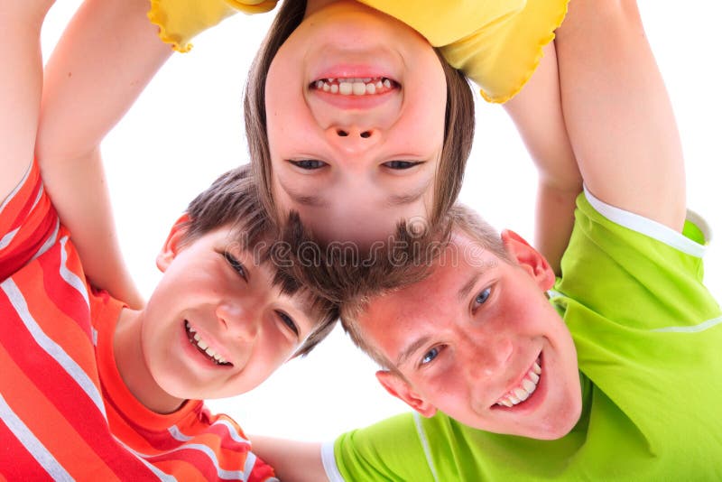 Studio portrait of a sister and two brothers with their heads together and looking downward. Studio portrait of a sister and two brothers with their heads together and looking downward.