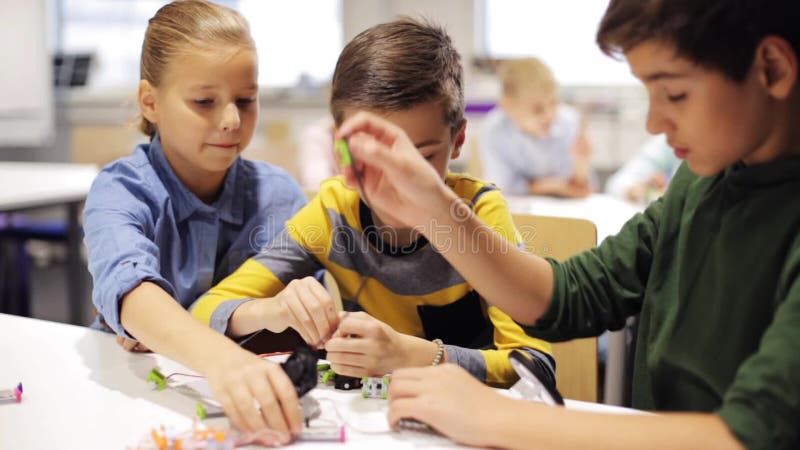 Crianças felizes que fazem a elevação cinco na escola da robótica