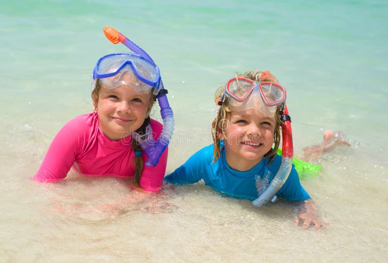 Crianças felizes que vestem mergulhando a engrenagem na praia foto de stock Crianças felizes que vestem mergulhando a engrenagem na praia foto de stock