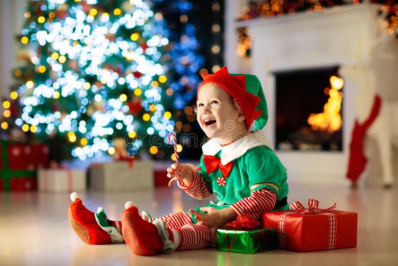 Crianças junto à árvore de Natal. Crianças abrem presentes fotografia de stock