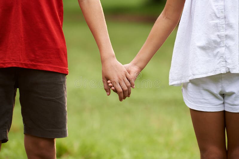 Crianças no amor, menino e menina que guardam as mãos fotos de stock Crianças no amor, menino e menina que guardam as mãos fotos de stock