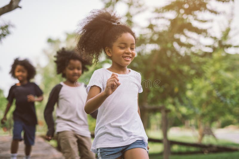 Crianças a brincar ao ar livre com amigos imagem de stock