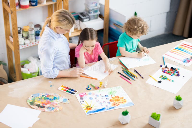 Crianças que tiram na classe de arte fotos de stock Crianças que tiram na classe de arte fotos de stock