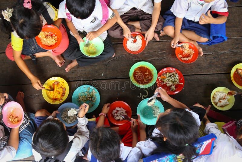 Crianças que têm o almoço na escola asiática imagem de stock Crianças que têm o almoço na escola asiática imagem de stock