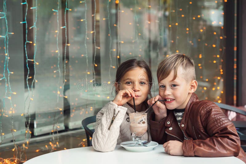 Crianças que têm o divertimento no café exterior imagens de stock royalty free