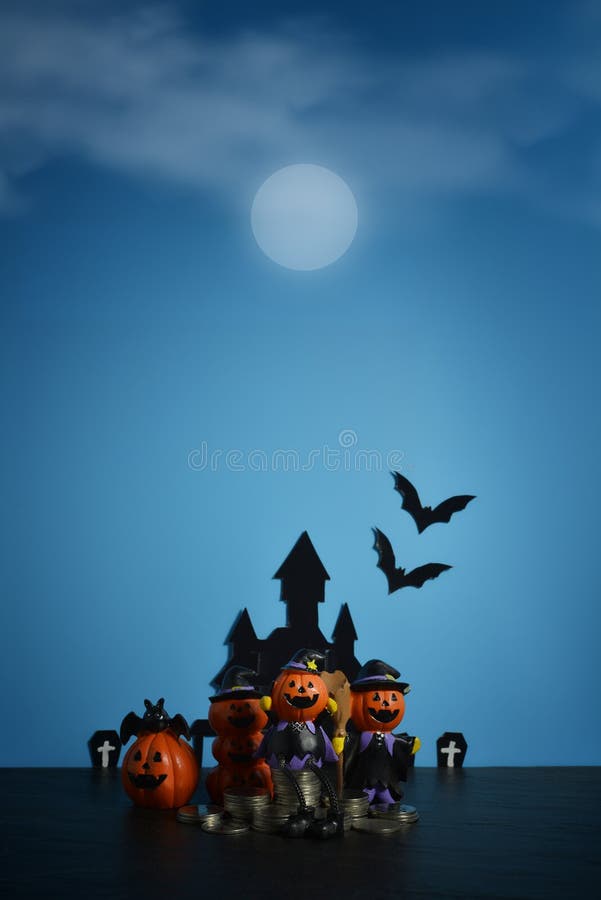 Cric-o-lanterne de potirons de Halloween avec des affaires croissantes de pile de pièce de monnaie d'argent sur le fond bleu-fonc photos libres de droits Cric-o-lanterne de potirons de Halloween avec des affaires croissantes de pile de pièce de monnaie d'argent sur le fond bleu-fonc photos libres de droits