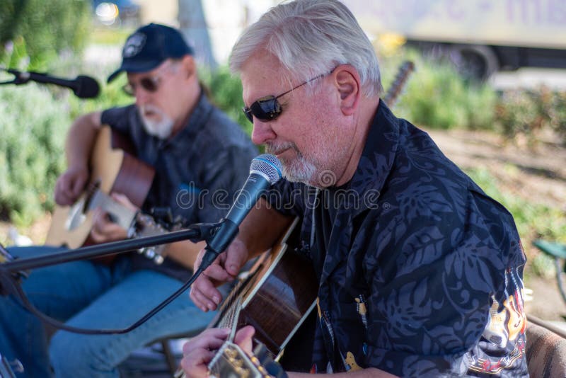 Cris Hagen and Mike play guitars as the entertainment band for the Simi Valley Farmer`s Market. Simi Valley, California / USA - January 7, 2020: Cris Hagen and stock image Cris Hagen and Mike play guitars as the entertainment band for the Simi Valley Farmer`s Market. Simi Valley, California / USA - January 7, 2020: Cris Hagen and stock image