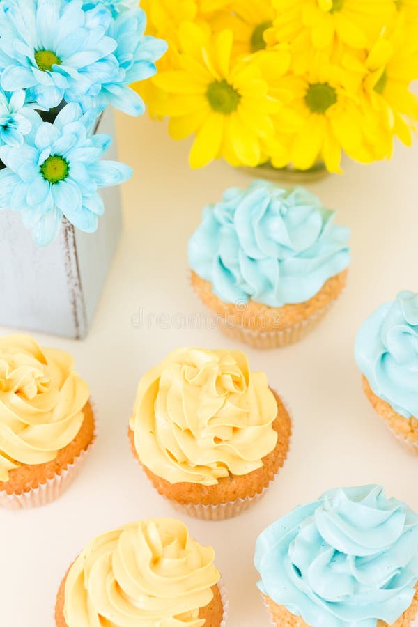 Crisantemo amarillo y azul en florero elegante lamentable con las magdalenas adornadas con crema blanda Área de Copyscape fotografía de archivo Crisantemo amarillo y azul en florero elegante lamentable con las magdalenas adornadas con crema blanda Área de Copyscape fotografía de archivo