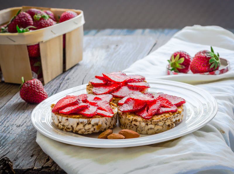 Crispbread с арахисовым маслом и свежими клубниками на круге стоковое изображение Crispbread с арахисовым маслом и свежими клубниками на круге стоковое изображение
