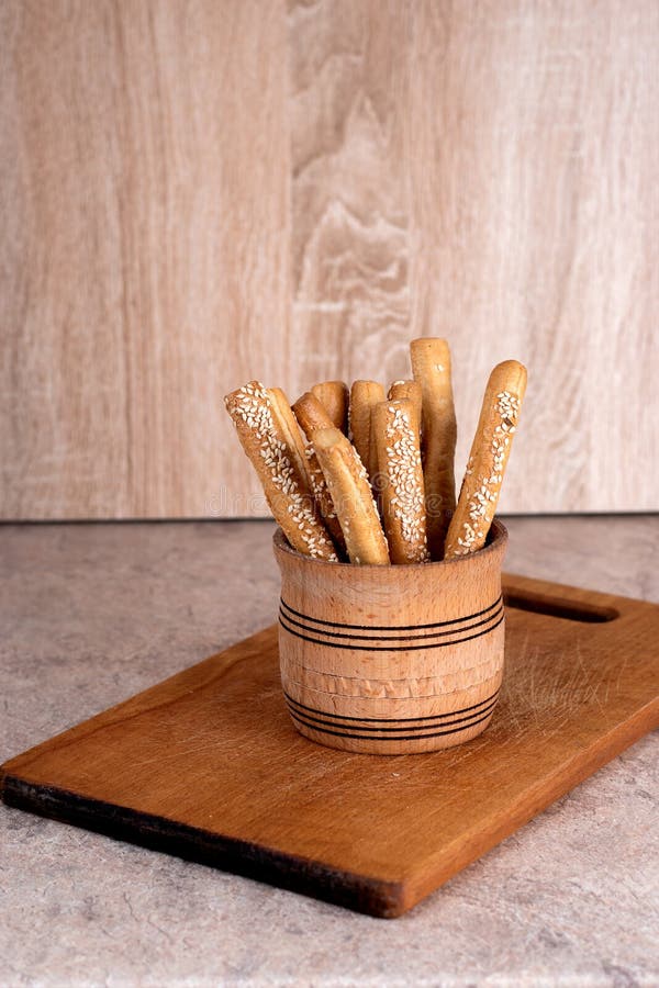 Crispy Bread Sticks with Sesame Seeds and Bran Bread on a Wooden Board