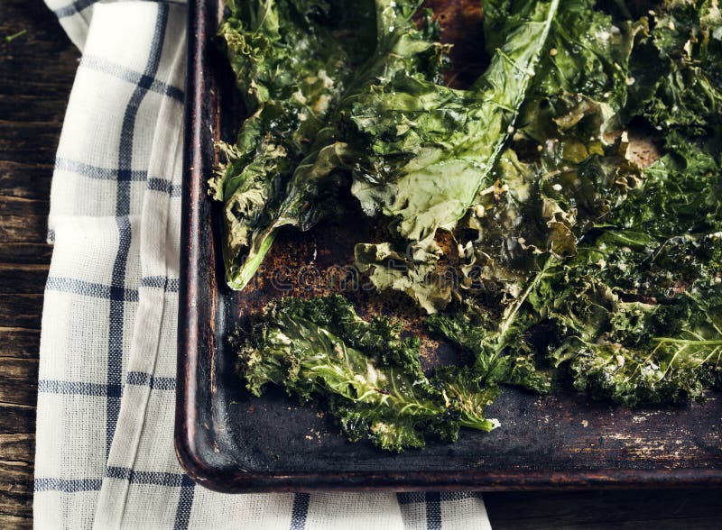 Crispy cheese and chili kale chips on baking tray. Toned image royalty free stock image