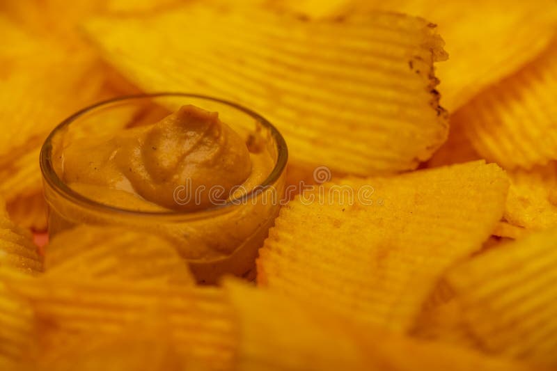 Crispy, Delicious Potato Chips with Mustard Sauce. Close Up Stock Photo