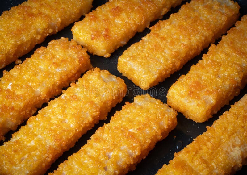 Crispy fish sticks frying in a pan close-up royalty free stock images
