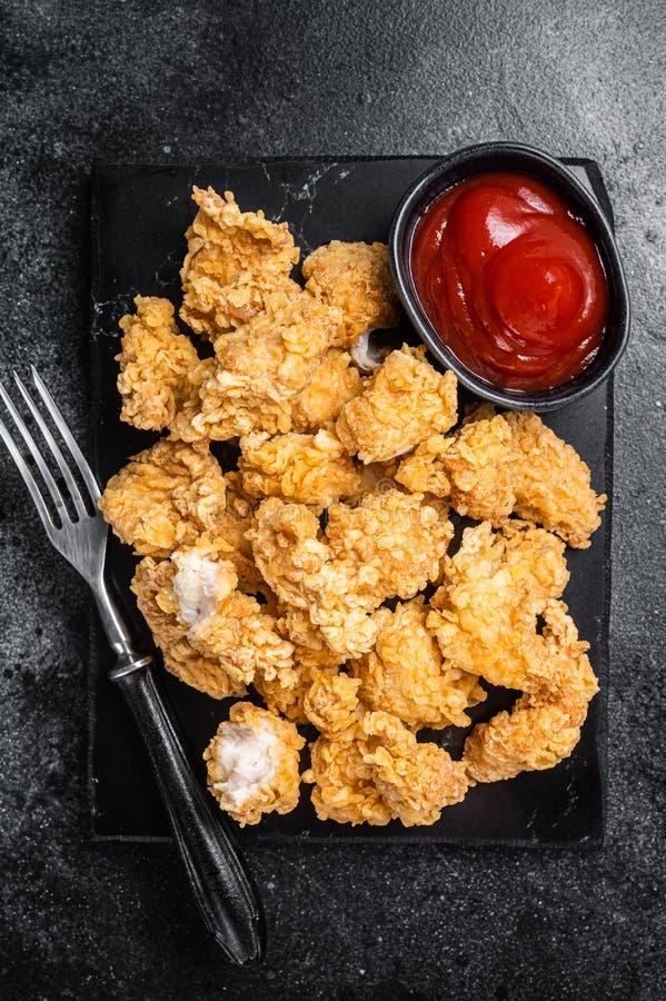 Crispy Fried Breadcrumb Covered Chicken Popcorn with Ketchup. Black