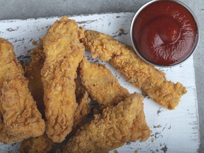 Crispy Fried Breaded Chicken Breast Strips and Sauce Stock Photo