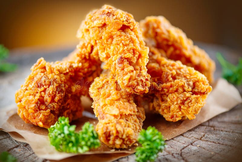 Crispy fried chicken wings on wooden table. Crispy fried kentucky chicken wings on wooden table royalty free stock photos