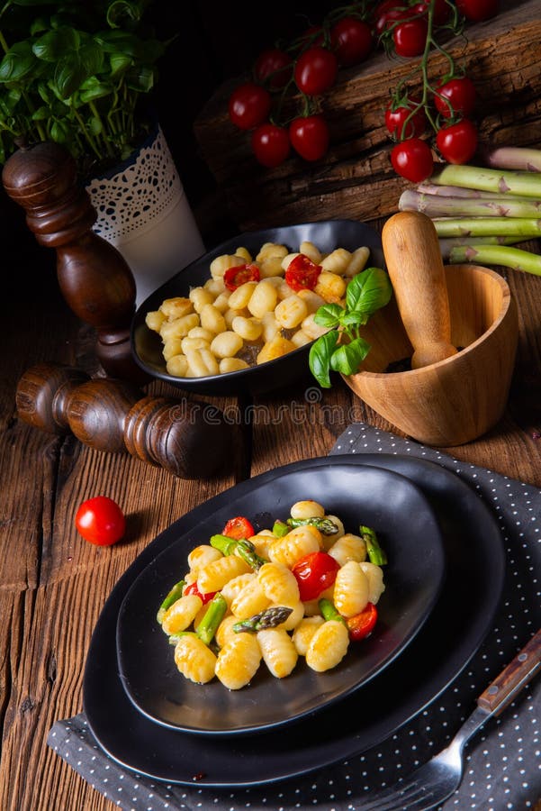A Crispy Gnocchi with Roasted Asparagus and Tomatoes Stock Photo