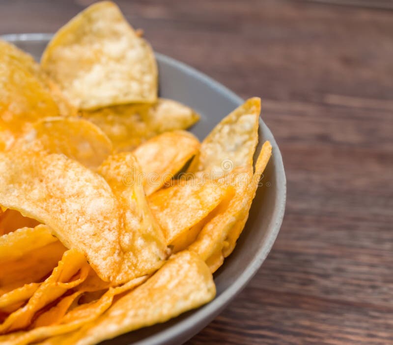Crispy Potato Chips in a Wicker Bowl on Old Kitchen Table Generative AI