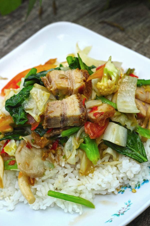 Crispy Roasted Pork Stir Fry with Vegetables and Rice. Stock Photo