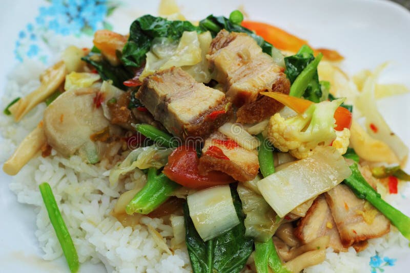 Crispy Roasted Pork Stir Fry with Vegetables and Rice. Stock Photo