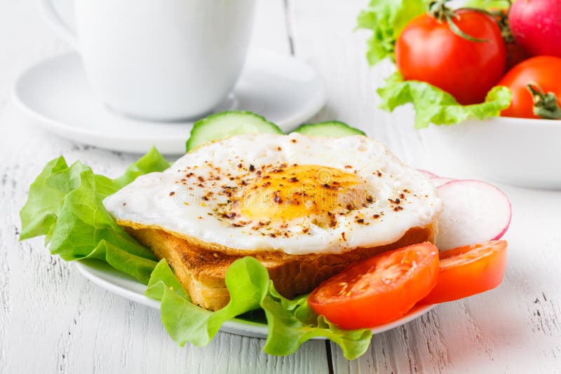 Crispy Toast with a Fried Egg and Fresh Arugula, a Cup of Coffee