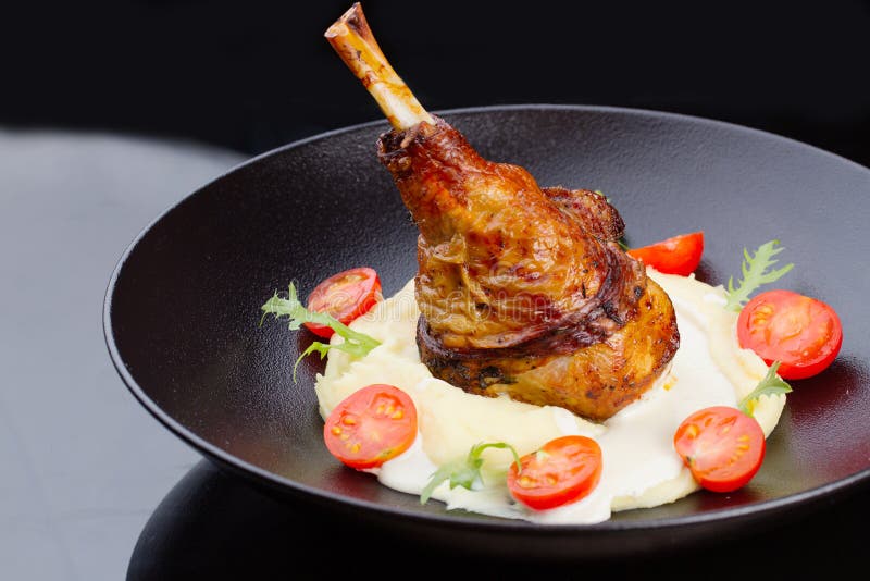 Crispy turkey leg with mashed potatoes and tomatoes stock photography Crispy turkey leg with mashed potatoes and tomatoes stock photography