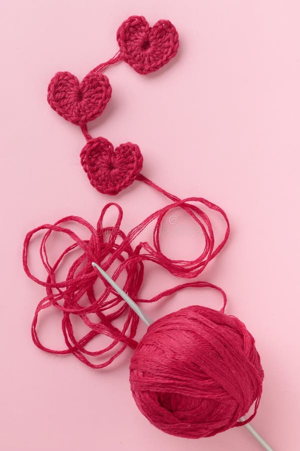 Premium Photo  Knitted heart of pink thread with crochet hooks