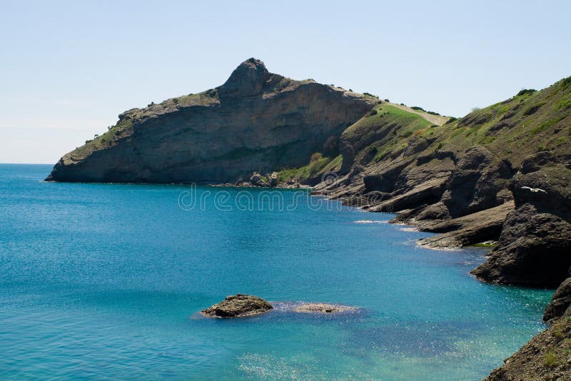 Crocodile shaped mountain in blue sea