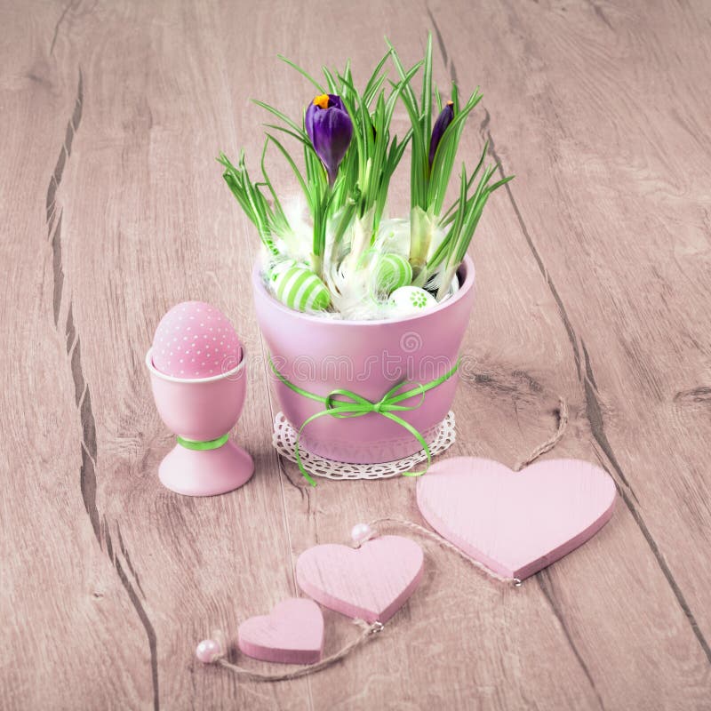 Crocus flowers and pink Easter decorations on wood