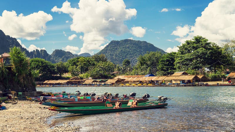 Crogioli di coda lunga sul tramonto al fiume di canzone, Vang Vieng, Laos fotografie stock Crogioli di coda lunga sul tramonto al fiume di canzone, Vang Vieng, Laos fotografie stock