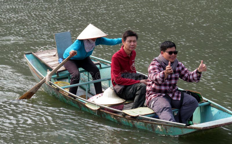 Crogiolo di pagaia con i turisti in Ninh Binh, Vietnam immagine stock libera da diritti Crogiolo di pagaia con i turisti in Ninh Binh, Vietnam immagine stock libera da diritti