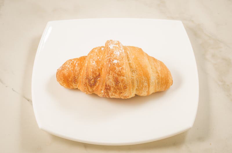 croissan in een witte plaat op een marmeren achtergrond/croissan in een witte vierkante plaat op een marmeren achtergrond Hoogste royalty-vrije stock afbeeldingen croissan in een witte plaat op een marmeren achtergrond/croissan in een witte vierkante plaat op een marmeren achtergrond Hoogste royalty-vrije stock afbeeldingen