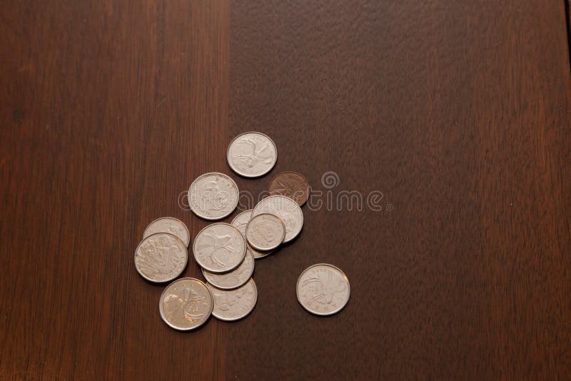 A pile of change on a wooden table. A pile of change on a wooden table