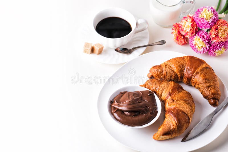 Croissant with chocolate hazelnut spread and cup of coffee