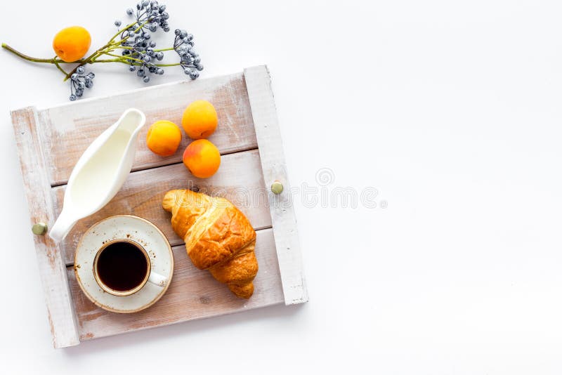 Croissant with cup of coffee and apricot for breakfast on white background top view copyspace