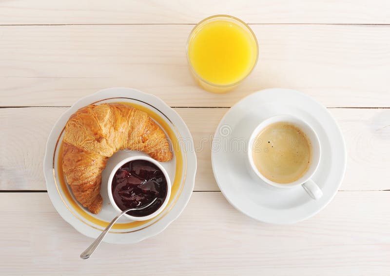 Croissant, dżem, kawa i sok pomarańczowy na drewnianym tle, fotografia stock Croissant, dżem, kawa i sok pomarańczowy na drewnianym tle, fotografia stock