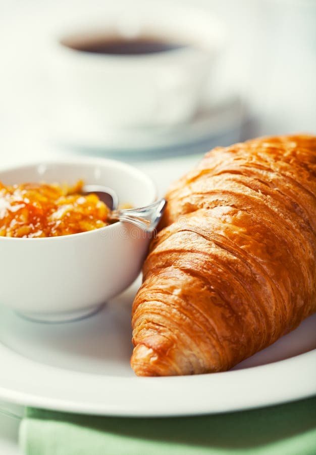 Croissant with orange jam on a plate