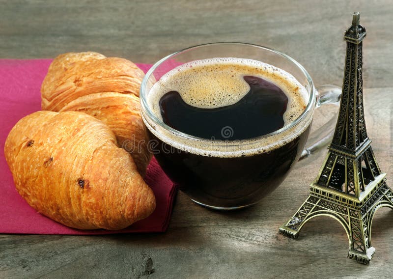 Croissant and Paris. croissants and eiffel tower as a souvenir. croissants and cup of coffee on a wooden table. top view. copy spa