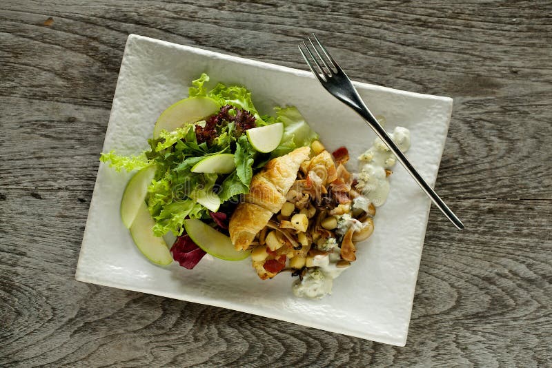 Breakfast - croissant with apple salad on the wooden background. Breakfast - croissant with apple salad on the wooden background