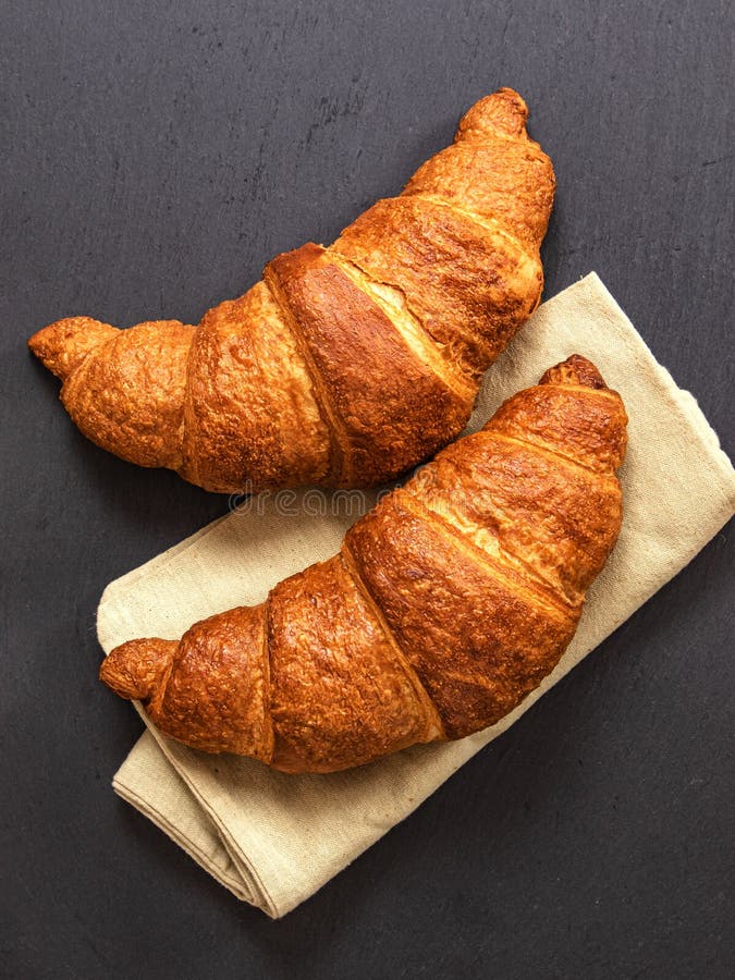 Croissants sobre fondo de pizarra gris Imagen vertical, vista superior imágenes de archivo libres de regalías
