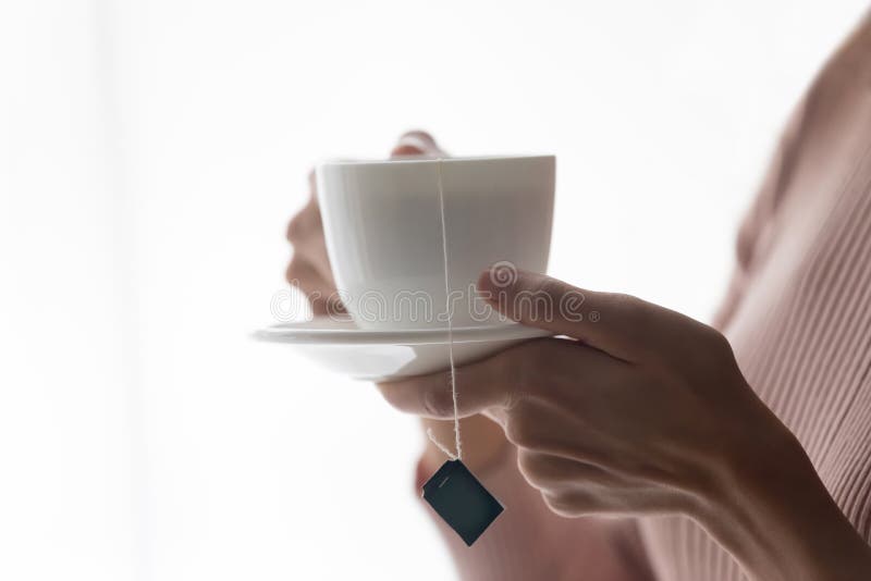 Close up of woman hold drink hot tea in mug