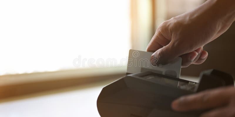 Cropped image of hands swipes a credit card at the card reader