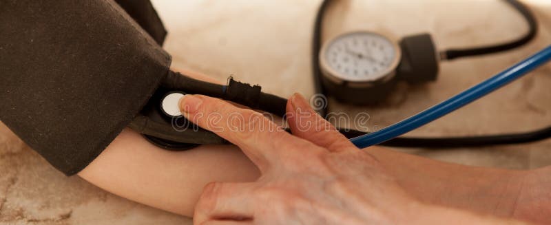 Cropped image of male doctor checking blood pressure of patient at table stock photos Cropped image of male doctor checking blood pressure of patient at table stock photos