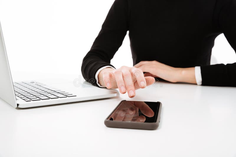 Cropped image of young business lady using laptop and phone. royalty free stock photo Cropped image of young business lady using laptop and phone. royalty free stock photo