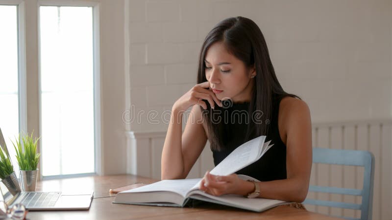 Cropped shot of college girl reading book to find information for her thesis