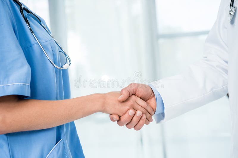 Doctor and nurse shaking hands royalty free stock photo