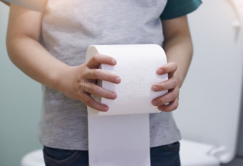 Cropped shot of kid hands holding toilet roll, little boy suffers from diarrhoea holding toilet paper, Low view Child bringing