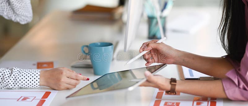 Cropped shot of two designer women is developing for mobile phone applications with a digital tablet. royalty free stock photography